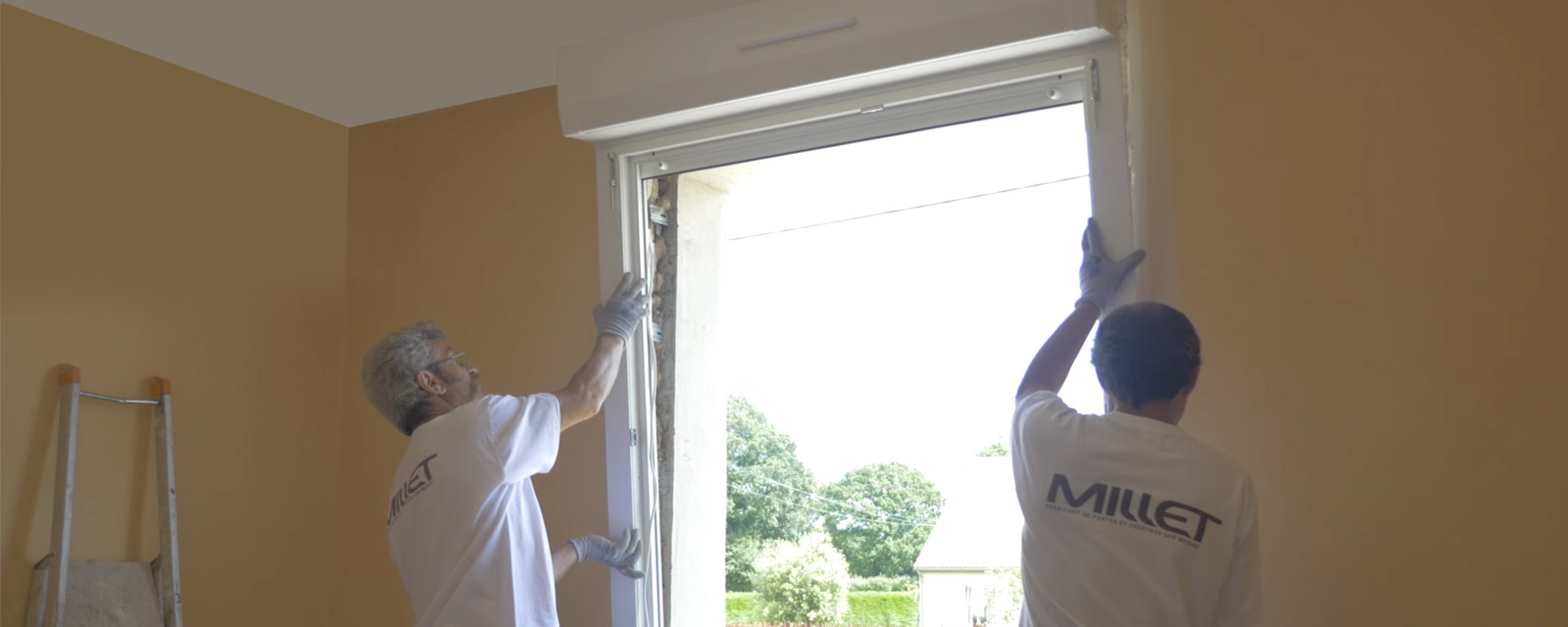professionnels retirant une fenêtre d'un mur