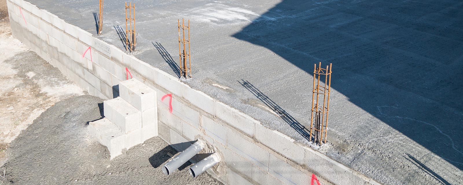 Un artisan réalisant l'étanchéité des soubassements d'une construction