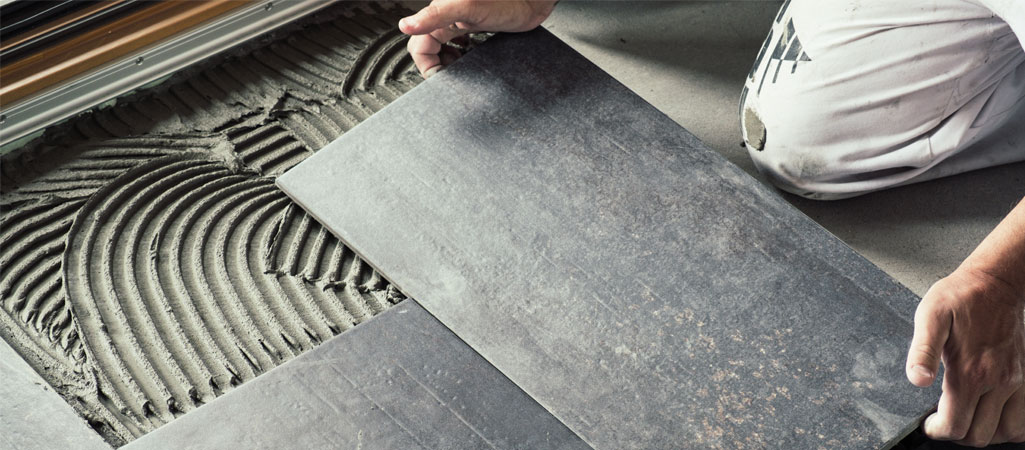 Pro effectuant la pose du carrelage 