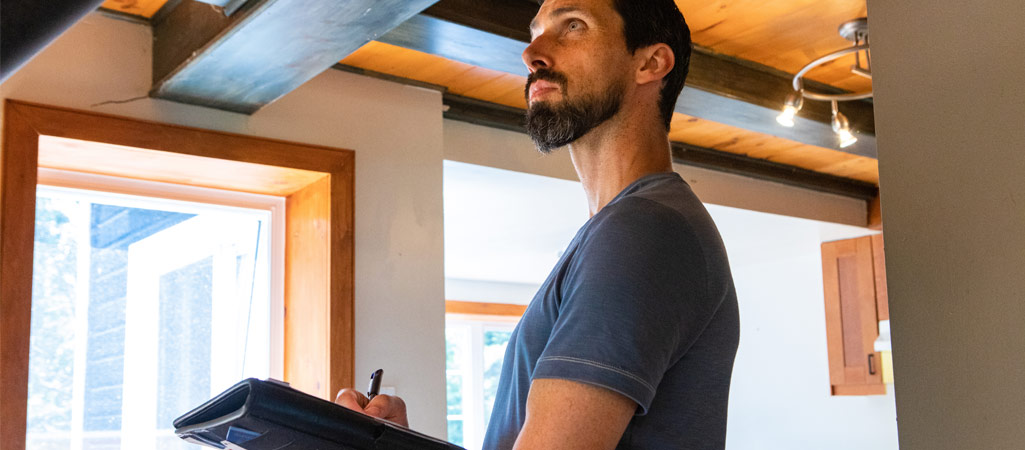 professionnel du bâtiment analysant une habitation